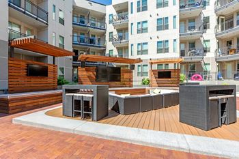 A modern outdoor seating area with a wooden deck and a television.